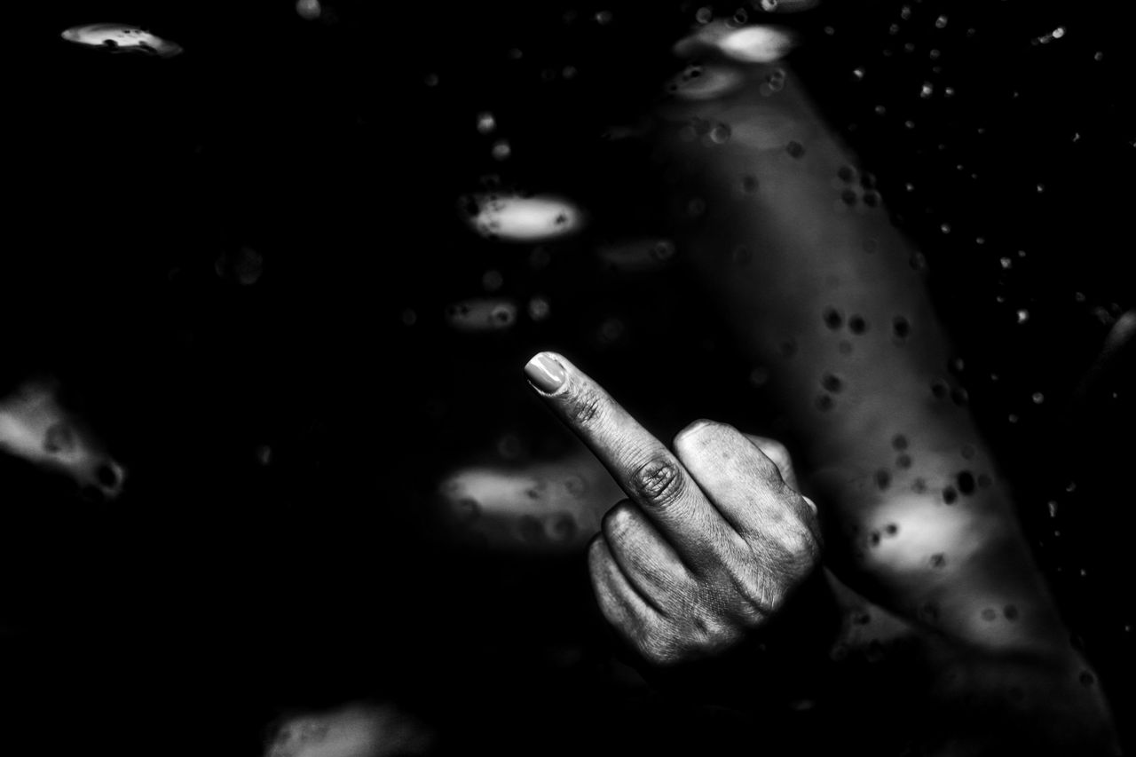faceless black person demonstrating middle finger