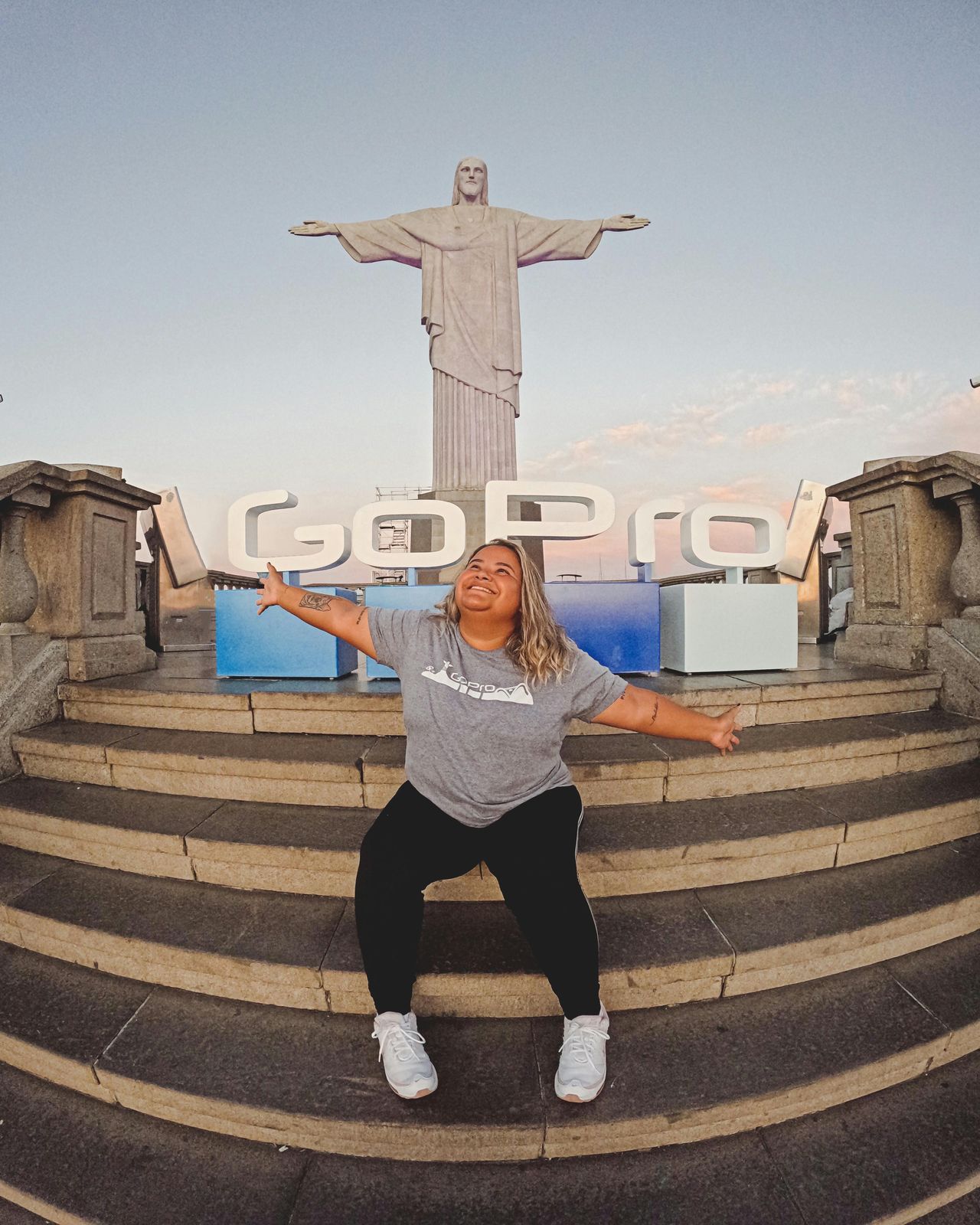 woman posing with christ the redeemer sculpture