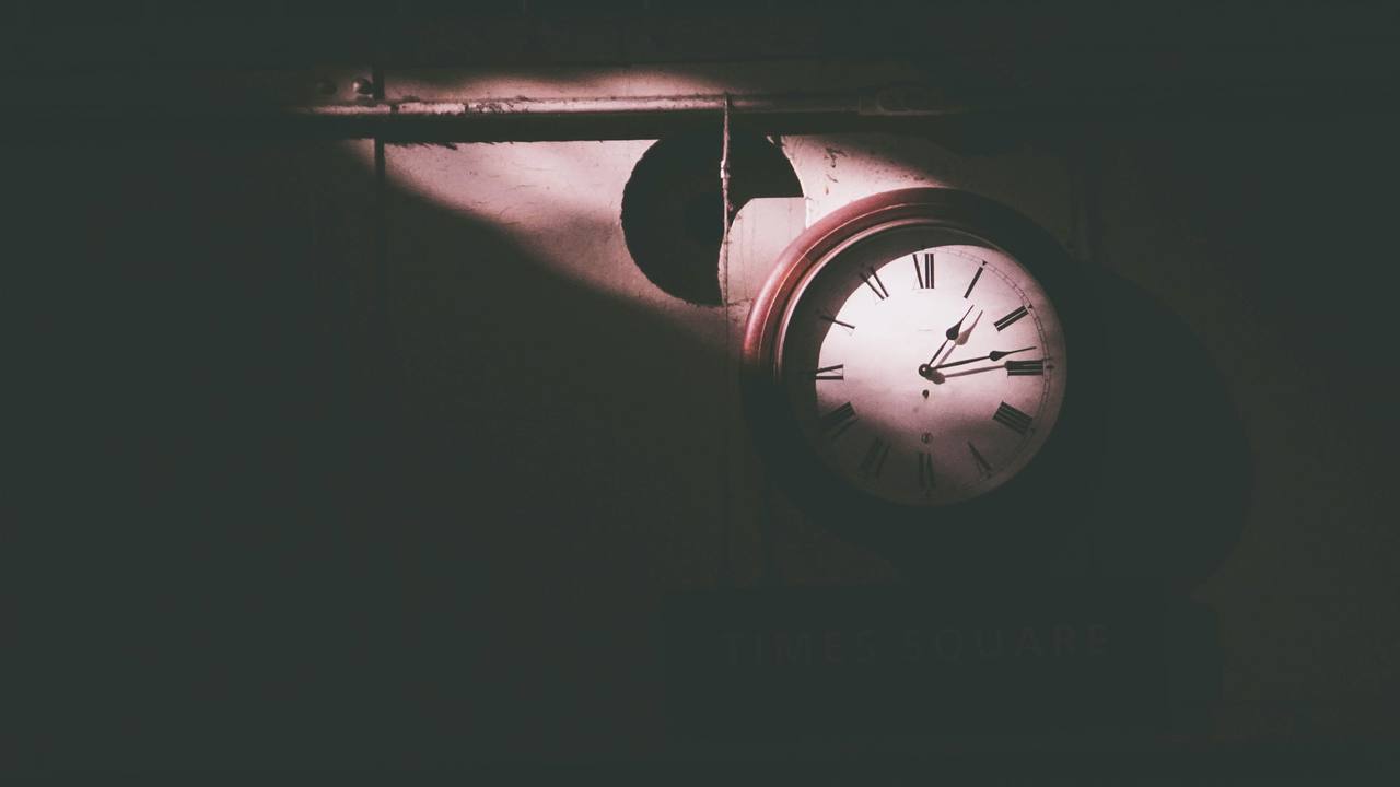An old clock with Roman numerals glowing in the dark